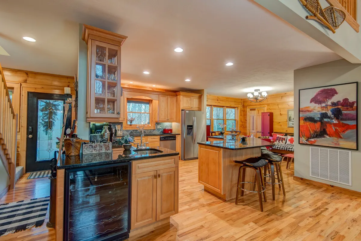 A warm, inviting kitchen centered around a generous island with granite countertops, complemented by stainless steel appliances and rich wooden cabinets. The open concept and stylish decor make it ideal for both meal preparation and entertaining guests.